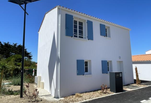 Façade avant d'une maison neuve en BRS à Le Brée-les-Bains sur l'Île d'Oléron avec volets bleus